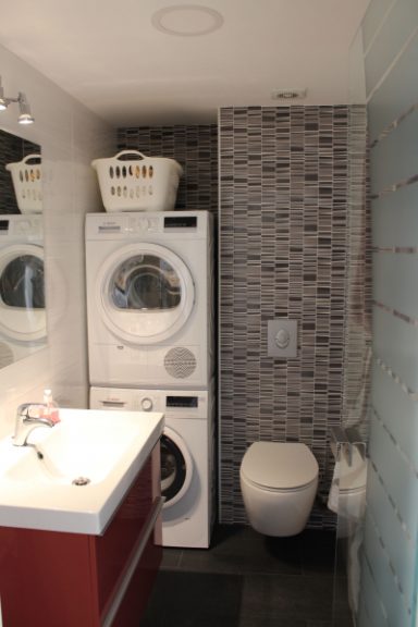 Toilette mit Waschbecken, Waschmaschine und Trockner